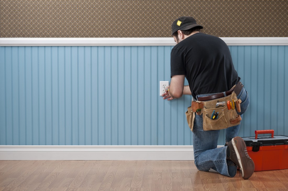 photo of electrician repairing outlet